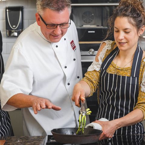 Chef tutor teaching a student to cook